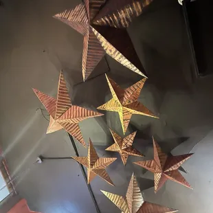 a bunch of paper stars hanging from the ceiling