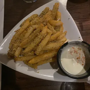a plate of french fries and dip