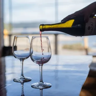 a person pouring a glass of wine