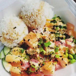 a takeout container with rice, vegetables, and meat