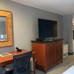Closer view of the desk and TV stand (refrigerator inside)