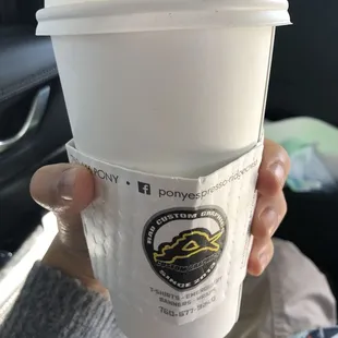 a hand holding a cup of coffee
