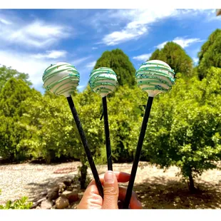 a hand holding three pops