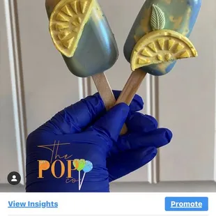 a hand holding two pops
