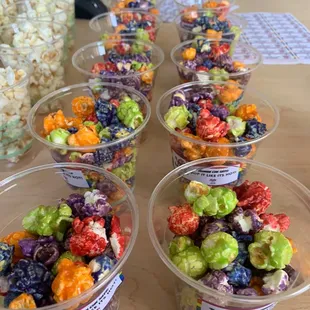 a row of plastic cups filled with popcorn