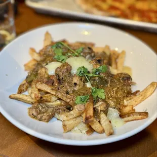 Pork green chili fries with cheddar cheese curds and lime