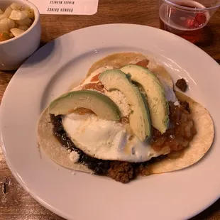 a plate of tacos and a bowl of fruit