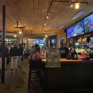 people sitting at the bar and watching televisions