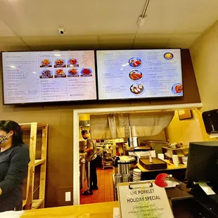 a woman standing in front of a menu