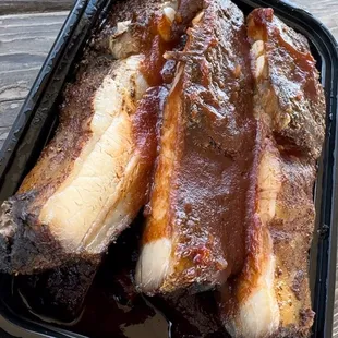 a tray of ribs with bbq sauce