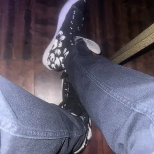 the feet of a person wearing black and white sneakers