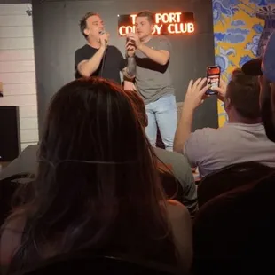 a man on a stage speaking to a group of people
