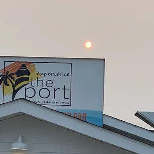 the sun setting over the roof of a building