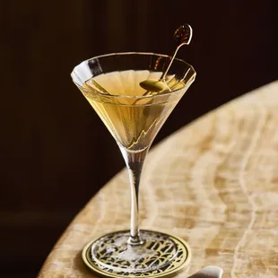 a glass of martini with olives in it