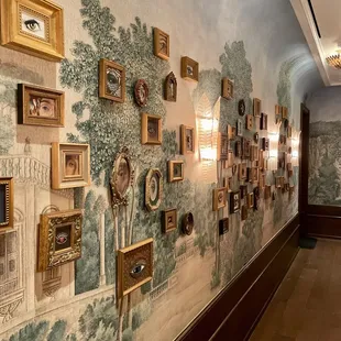 a wall with many framed pictures