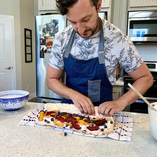 Rolled pavlova with apricots, apriums, blueberries, and almonds