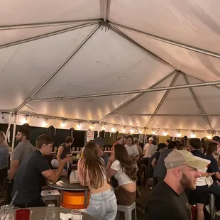 a large group of people eating under a tent