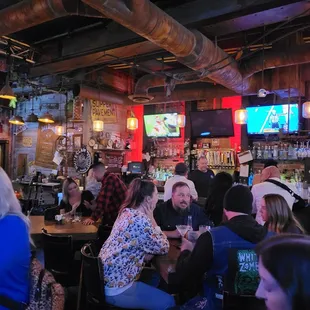 a crowded bar with people sitting at tables
