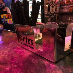 a bar with a bar counter and neon lights