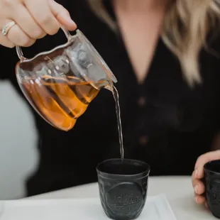 6 rotating flavors of tea served in a glass carafe with custom handmade tea cups