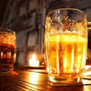 two mugs of beer on a bar