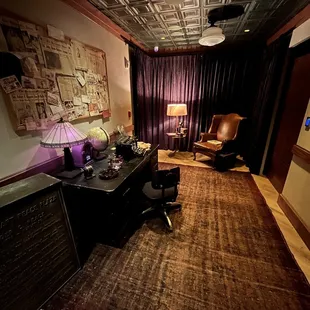 a desk with a lamp and a chair