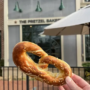 a hand holding a pretzel