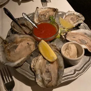 a platter of oysters with dipping sauce