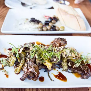 Kalbi Ribs with shishito peppers, and the roasted feta and olives in the background.