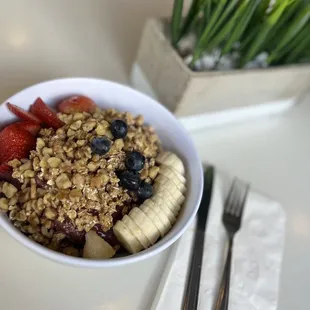 a bowl of granola with strawberries and bananas