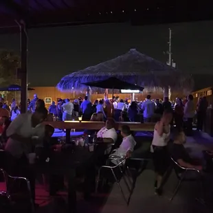 people sitting at tables under umbrellas