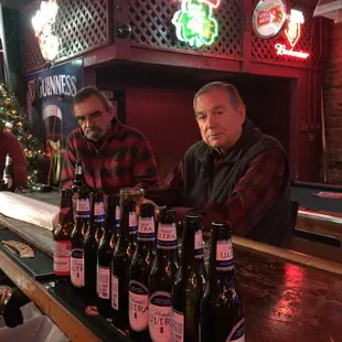 two men sitting at a bar