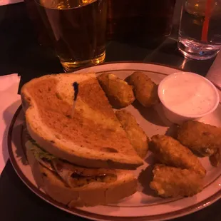 Half of a pub club sandwich with a side of jalapeño poppers