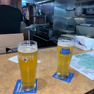 two glasses of beer on a counter