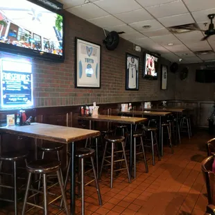 a row of bar stools in front of a television
