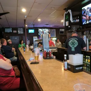 people sitting at the bar watching television
