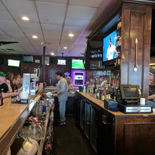 customers at the bar and televisions in the background