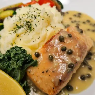 Seared salmon in a piccata creamsauce, mash potatoes, and sautéed vegetables
