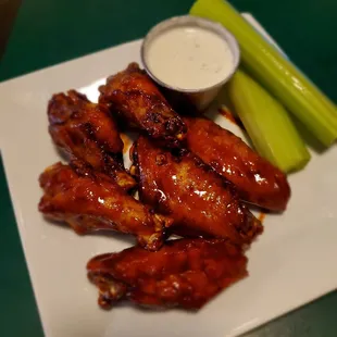 a plate of chicken wings and celery sticks