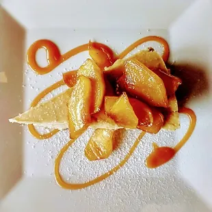 a plate of food with oranges and powdered sugar