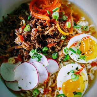 a bowl of ramen with meat and vegetables