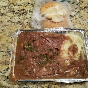 Pot Roast with carrots and mushrooms.  Mash potatoes on the bottom and two dinner rolls in a baggie