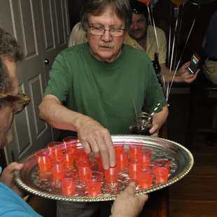 a man holding a tray of red candles