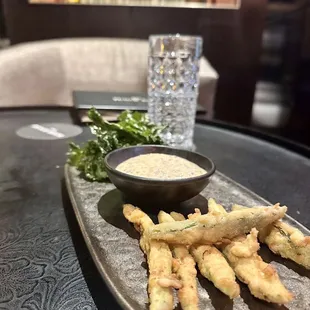 a platter of fried vegetables and dipping sauce