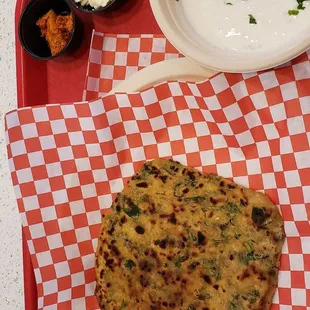 Fresh methi parantha with onion cucumber raita, spicy mango acchar, and butter