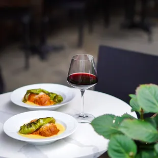 two plates of food and a glass of wine