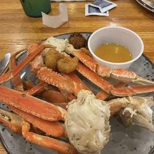 a plate of crab legs and a bowl of dipping sauce