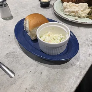The roll and coleslaw with the chicken meal