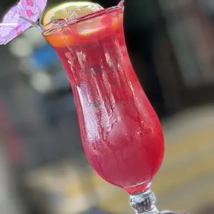 a red drink with a purple umbrella