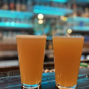 two glasses of beer on a bar